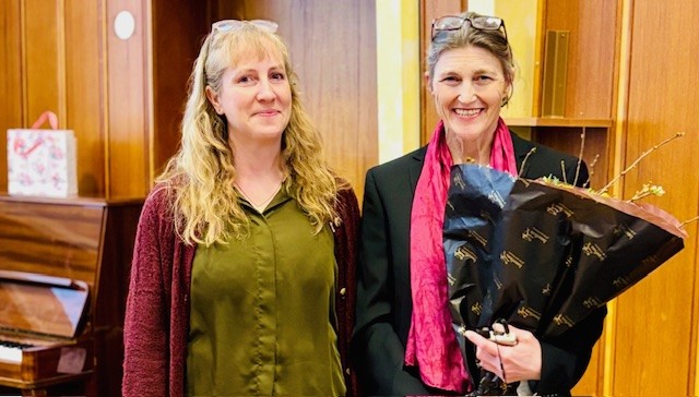 Silje Larsen og Lynn Skeie. Begge smiler. Skeie holder en blomsterbukett.